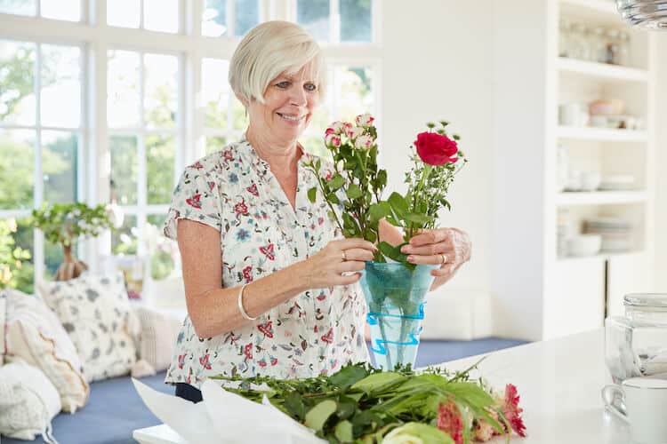 Senior woman arranging flowers while staging her home.