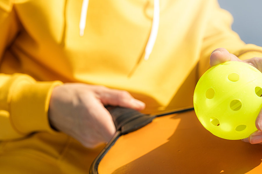 A close-up shot of a pickleball paddle and ball.