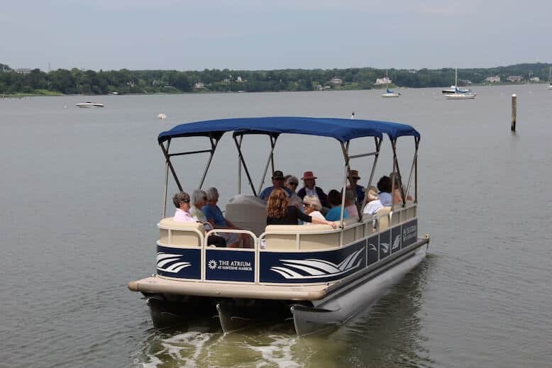 A pontoon boat travels the Navesink River.