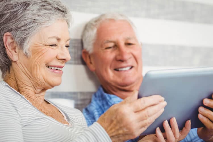 Couple using an iPad to find ways to save money for retirement.