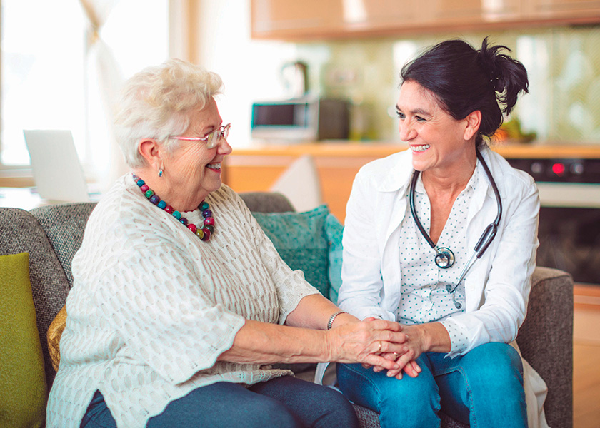 Senior Woman and Nurse or Doctor Smiling at One Another