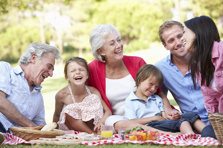 A multi-generational family enjoys an outdoor picnic on a sunny Spring afternoon.