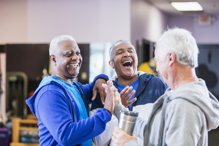 Three senior men hanging out at gym, talking