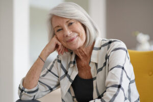 Stylish senior woman sitting casually indoors and smiling