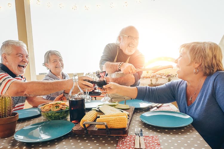 Seniors socializing outside over a glass of wine