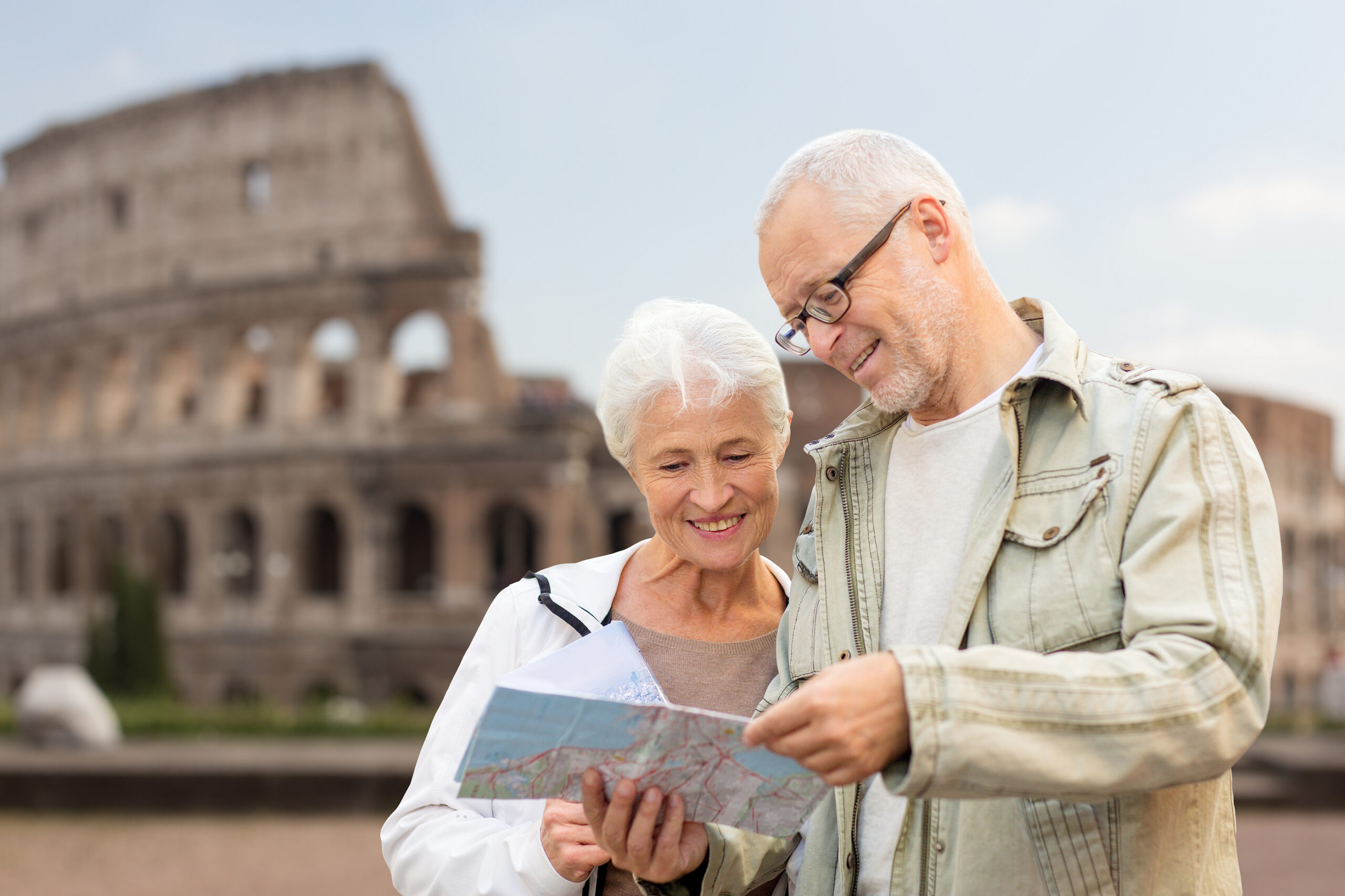 A senior couple stands looking at a map in Rome