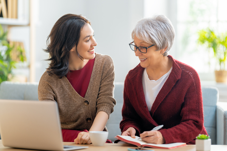 Senior and Adult Women Talking with Paperwork