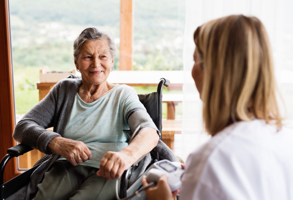 Senior Woman in Wheelchair Smiling at Doctor