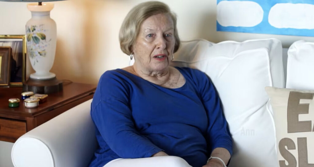 senior woman in blue sweater sitting cross legged