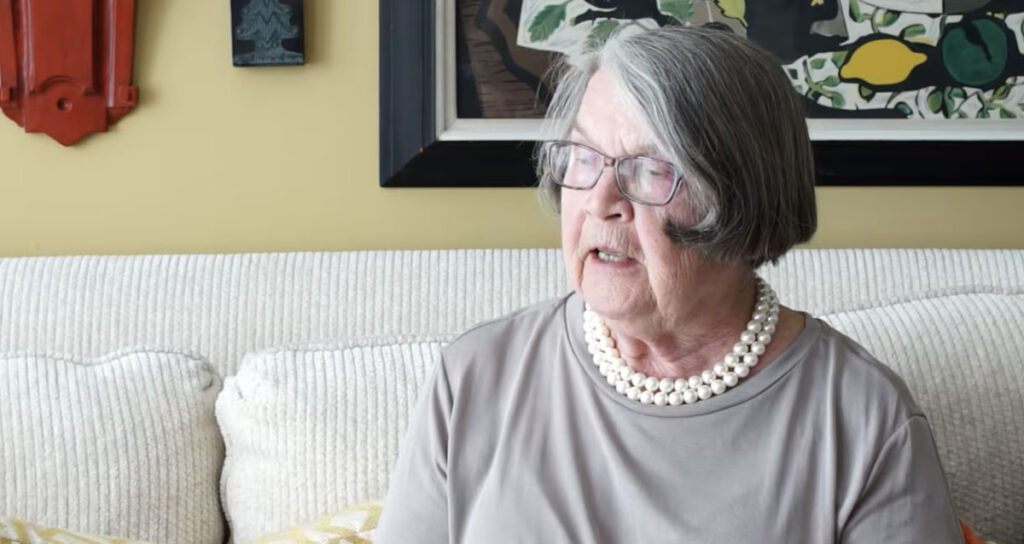 senior woman sitting on couch with pearl necklace