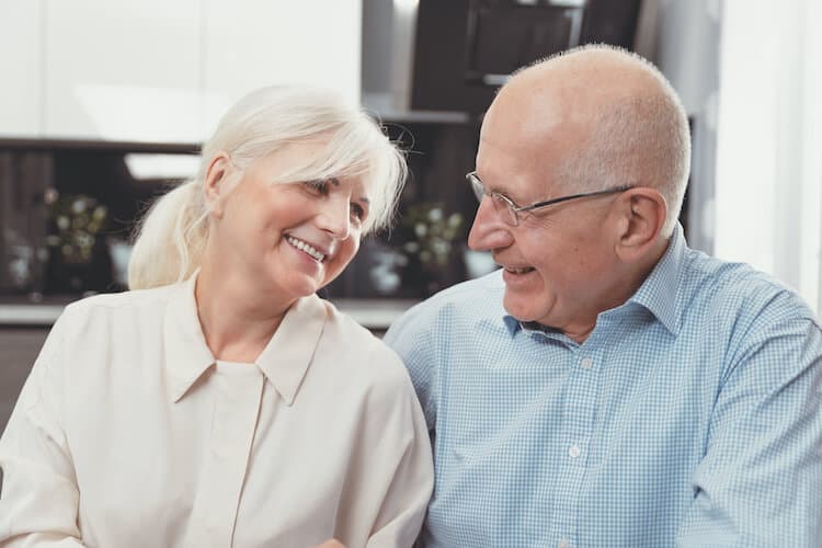 Elderly couple looking at each other and smiling